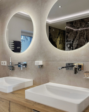 Modernes Badezimmer mit sandfarbenen Fliesen und braunen Marmorfliesen, Doppel-Aufsatzwaschbecken mit Chrom-Armaturen, freistehender Badewanne und barrierefreier Dusche mit Regenduschsystem für stilvolles, funktionales Design. Petri Heizung &amp; Sanitär, Mühlheim am Main