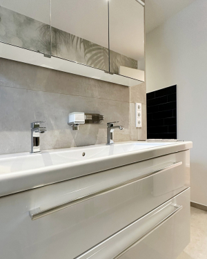 Modernes Badezimmer mit bodentiefer Dusche mit Regenduschsystem, Doppelwaschbecken mit Spiegel und Chrom-Armaturen, sandfarbenen Fliesen und beige/braune Wandfliesen in Marmoroptik. Petri Heizung &amp; Sanitär, Mühlheim am Main