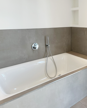 Elegantes Badezimmer mit bodentiefer Dusche mit Regenduschsystem, Doppel-Aufsatzwaschbecken mit Spiegel, Badewanne, sandfarbenen Bodenfliesen und beige/braune Wandfliesen in Marmoroptik. Petri Heizung &amp; Sanitär, Mühlheim am Main