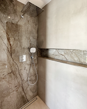 Elegantes Badezimmer mit bodentiefer Dusche mit Regenduschsystem, Doppel-Aufsatzwaschbecken mit Spiegel, Badewanne, sandfarbenen Bodenfliesen und beige/braune Wandfliesen in Marmoroptik. Petri Heizung &amp; Sanitär, Mühlheim am Main