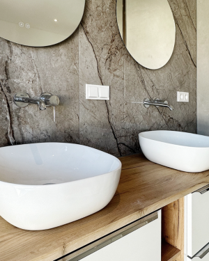 Elegantes Badezimmer mit bodentiefer Dusche mit Regenduschsystem, Doppel-Aufsatzwaschbecken mit Spiegel, Badewanne, sandfarbenen Bodenfliesen und beige/braune Wandfliesen in Marmoroptik. Petri Heizung &amp; Sanitär, Mühlheim am Main