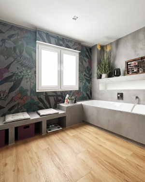 Badezimmer in Betonoptik mit Holzfliesenboden, barrierefreier Dusche mit Regenduschsystem, altersgerechten Sitzmöglichkeiten und Aufsatz-Waschbecken mit Holz-Waschtischunterschrank für stilvolles, funktionales Design. Petri Heizung &amp; Sanitär, Mühlheim am Main