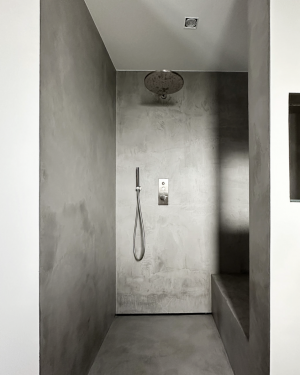 Badezimmer in Betonoptik mit Holzfliesenboden, barrierefreier Dusche mit Regenduschsystem, altersgerechten Sitzmöglichkeiten und Aufsatz-Waschbecken mit Holz-Waschtischunterschrank für stilvolles, funktionales Design. Petri Heizung &amp; Sanitär, Mühlheim am Main