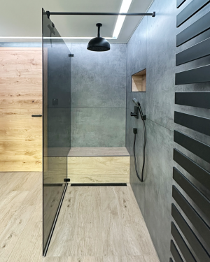 Modernes Badezimmer mit anthrazitfarbenen Wandfliesen, Holzfliesenboden, Waschtischunterschrank aus Holz, großem Doppelwaschtisch, schwarz-matte Armaturen, Toilette, Bidet, Badewanne und barrierefreier Dusche mit Regenduschsystem für stilvolles und funktionales Design.