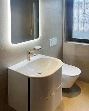 Modernes Gäste-WC mit sandfarbenen Fliesen, gold-matten Armaturen und Hänge-WC. Petri Heizung &amp; Sanitär, Mühlheim am Main.