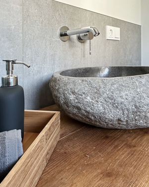 Modernes Gästebad mit Wandfliesen in Rostoptik, anthrazitfarbenen Bodenfliesen, Waschtischunterschrank aus Holz, Aufsatz-Waschbecken aus Granit und barrierefreier, ebenerdiger Dusche mit Regenduschsystem – stilvolles und funktionales Design. Petri Heizung &amp; Sanitär, Mühlheim am Main.