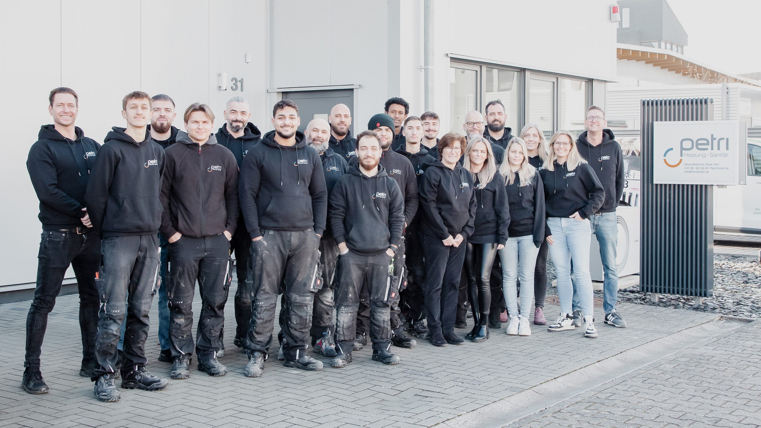 Mitarbeiter:innen der Petri Heizung & Sanitär GmbH in Mühlheim am Main posieren gemeinsam für ein Teamfoto, zeigen Teamgeist und Professionalität. Petri Heizung & Sanitär, Mühlheim am Main